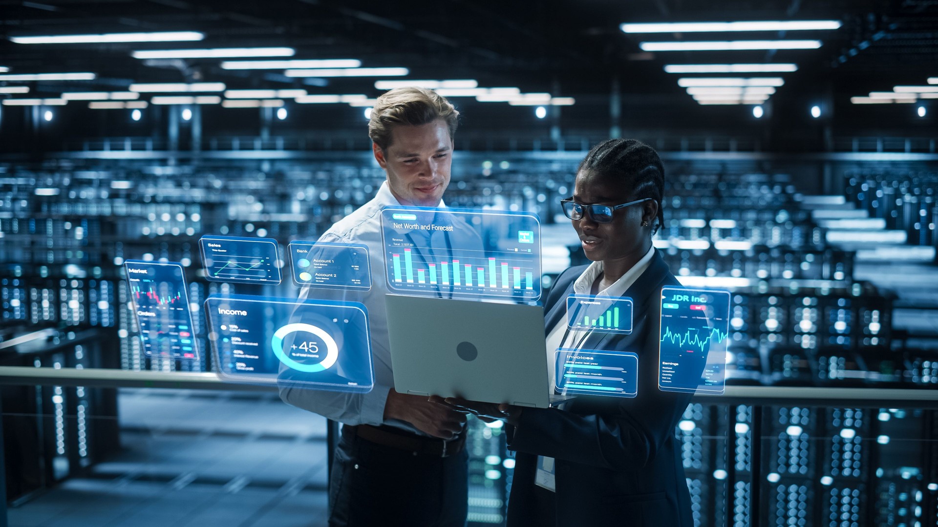 Technical Engineer and Project Administrator Using Computer in Modern Data Center Server Room Facility. Augmented Reality Productivity and Corporate Business Data Icons Appear From Worker's Laptop.
